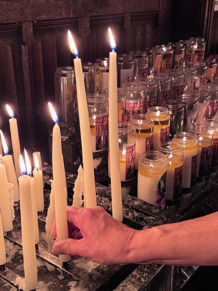 Person zündet Kerze in der Liebfrauenbasilika an